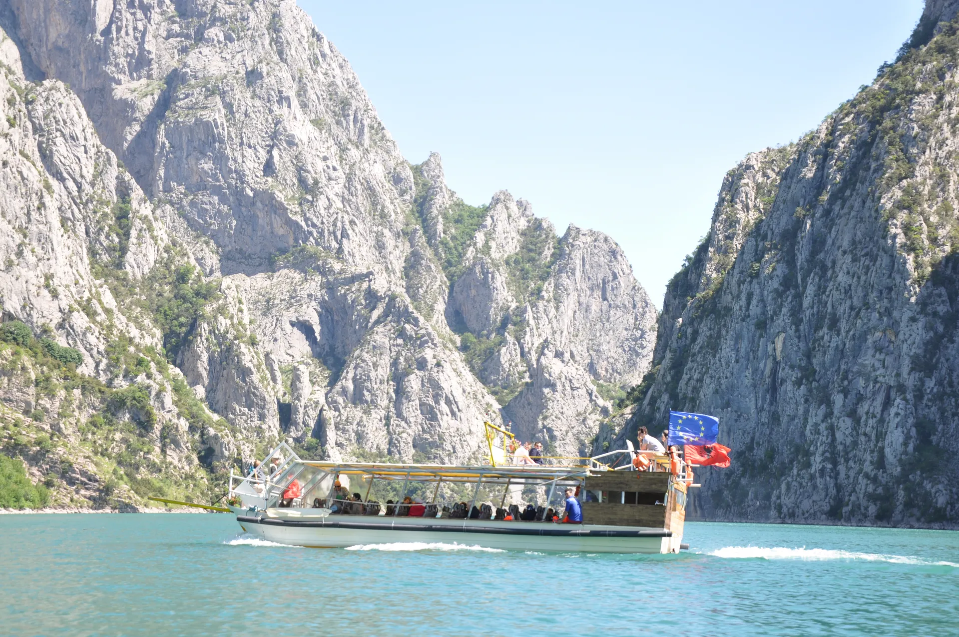 Tour boat cruising beneath the sheer limestone walls of the canyon.