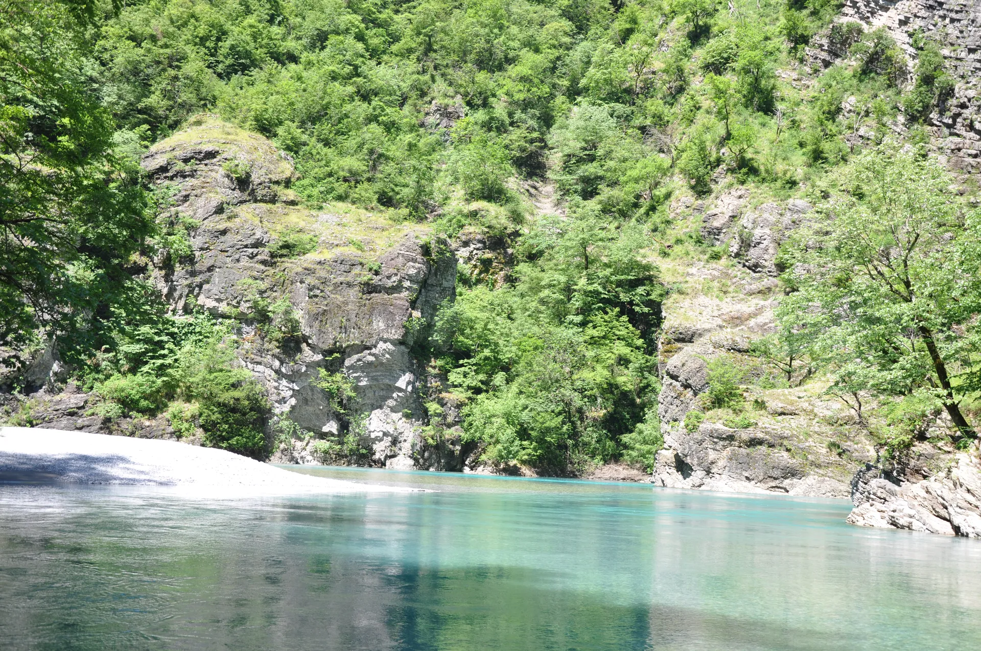 Lush vegetation growing on the steep limestone cliffs above the turquoise river.