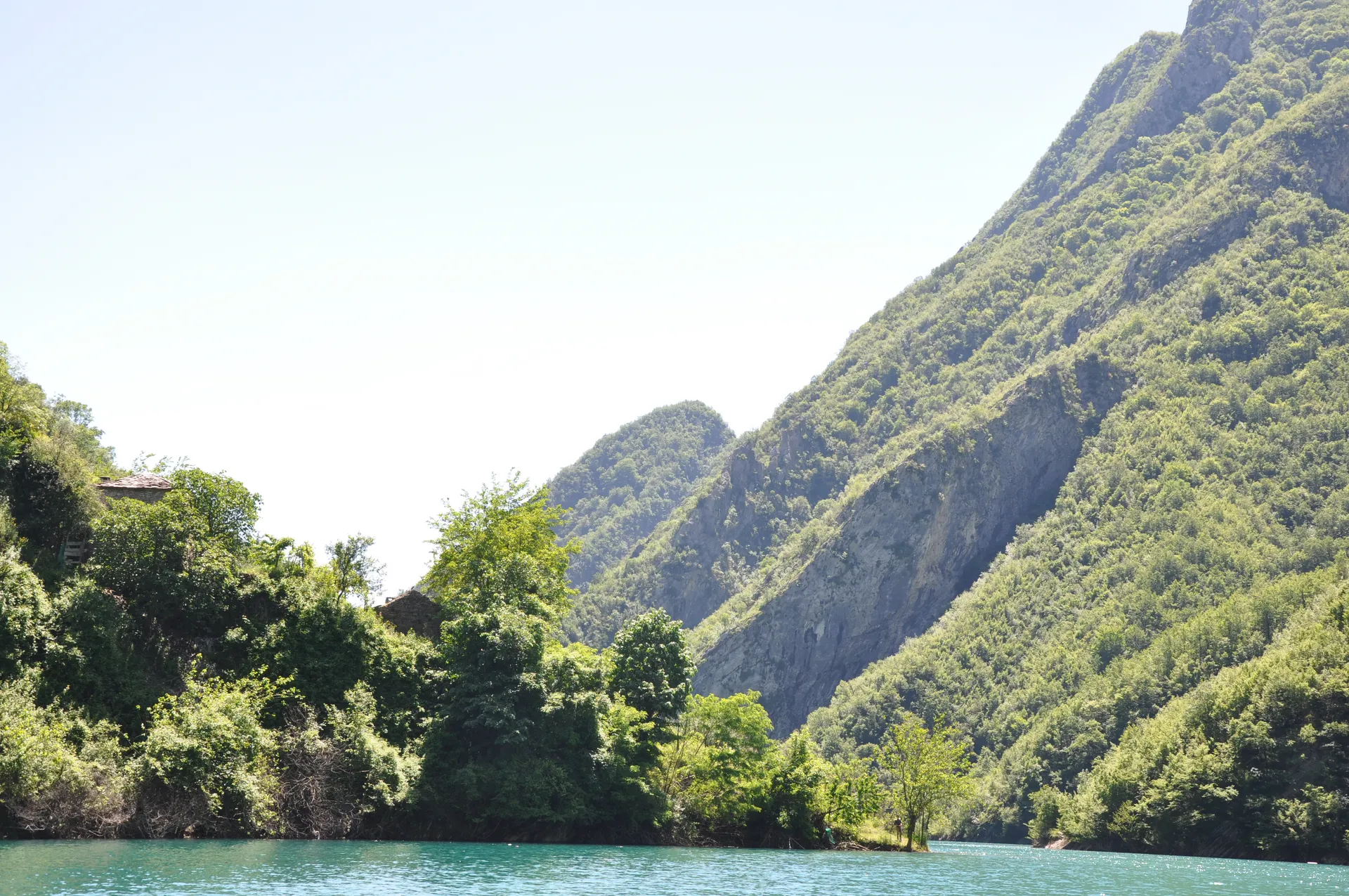 Scenic view of the lush green mountains sloping down to the turquoise water.