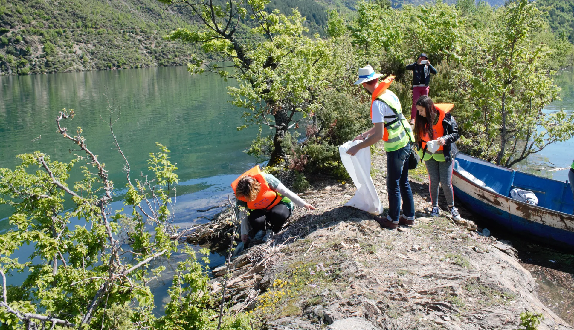 Tour guests working together to help clean up the lake