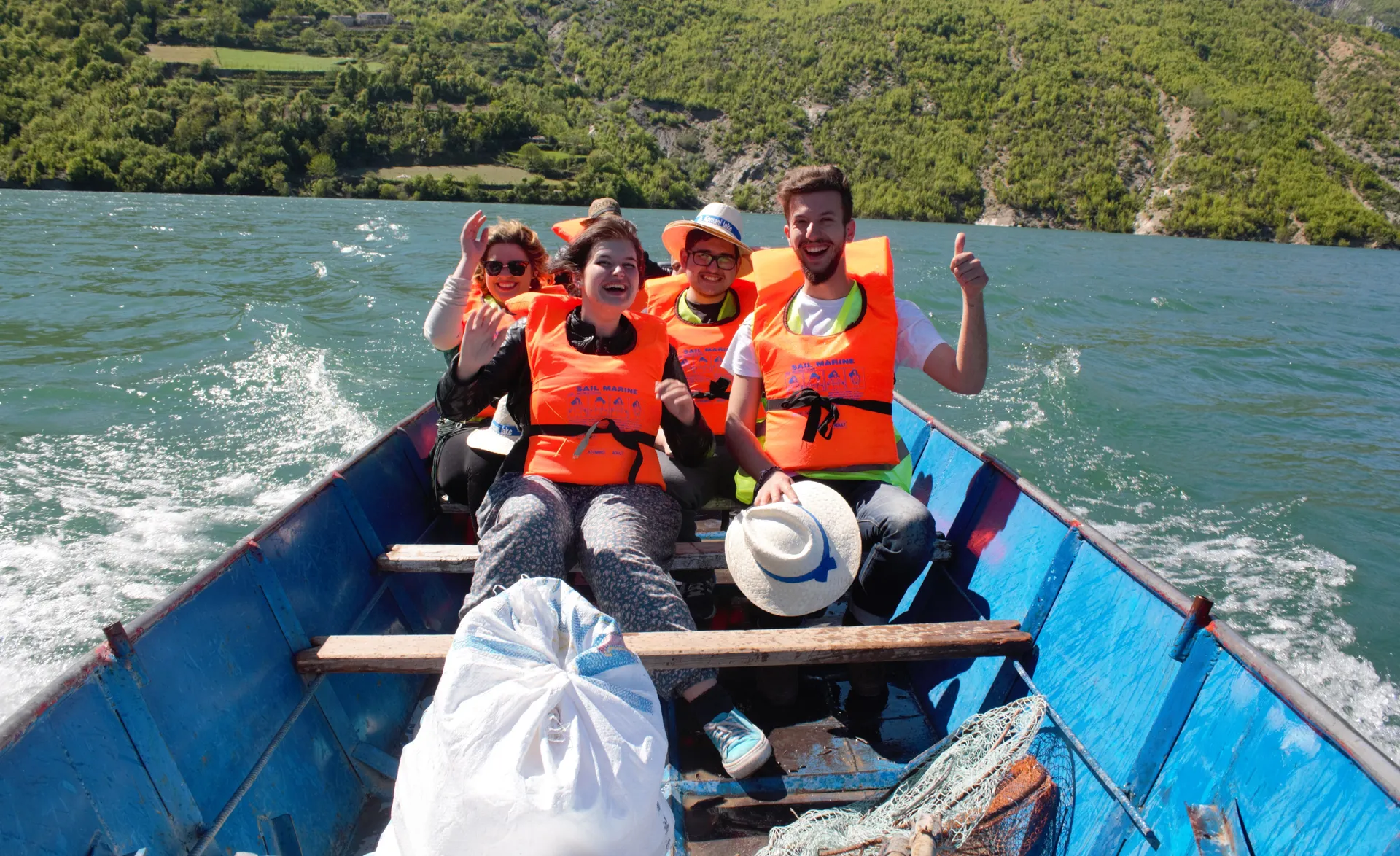 Turists in safety vests enjoying the thrill of a high-speed boat ride on Koman Lake.