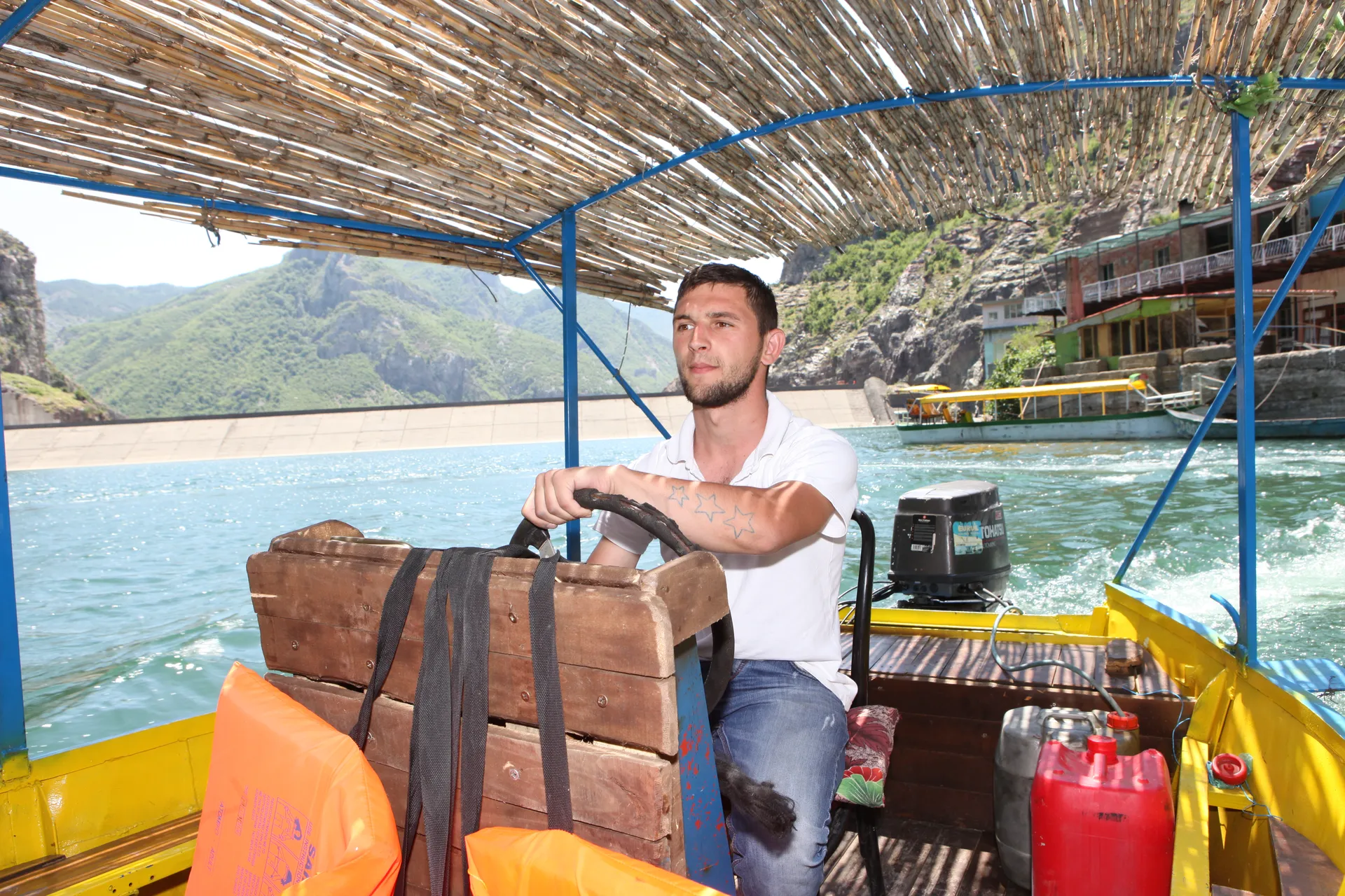 Experienced boat captain navigating the Shala River with focus and care.